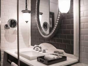 萨帕Hotel de la Coupole - MGallery的一间带水槽和镜子的浴室