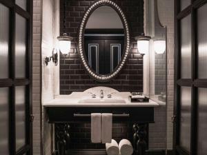 萨帕Hotel de la Coupole - MGallery的一间带水槽和镜子的浴室