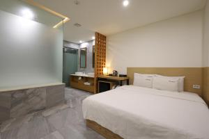 釜山TRT Hotel的卧室配有白色大床和水槽