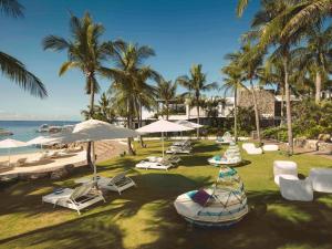 麦克坦宿务麦丹岛慕温匹克酒店的海滩上设有椅子和遮阳伞,还有大海