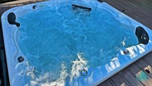 Marks PointVillage Bay Lakehouse - Spa, Pool table and Lake的设有一个蓝色水的按摩浴缸