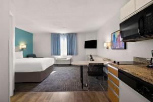 米德瓦尔MainStay Suites Salt Lake City Fort Union的配有一张床和一张书桌的酒店客房