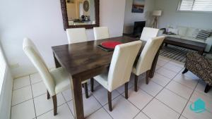 TeralbaThe Pelicans Rest的一间带木桌和白色椅子的用餐室