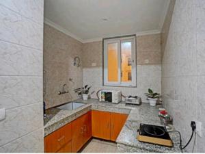 古尔冈Niketan Medanta Service Apartment - A BOUTIQUE HOTEL的厨房配有水槽和台面