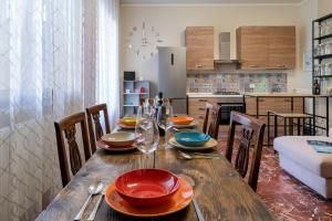 马尔米堡Villino Claudia的厨房里一张木桌,上面放有盘子和玻璃杯