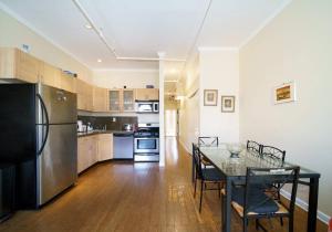纽约Lovely 1 BR Apartment in Manhattan的厨房配有桌子和黑冰箱。