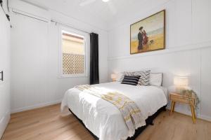 布里斯班Just Steps to South Bank & CBD-Your Charming Queenslander Retreat- Urban Escape!的白色的卧室设有床和窗户