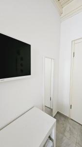 博兹贾阿达岛Ada Kalimera Bozcaada的白色的房间,白色的墙上配有电视