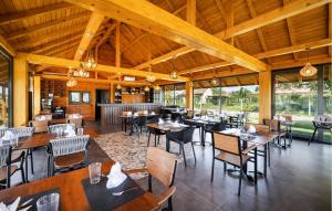 比尔杰Awesome Home In Bilje With Outdoor Swimming Pool的餐厅设有木制天花板和桌椅