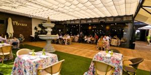 巴达霍斯博维达斯酒店的一间带桌椅的餐厅和一个喷泉