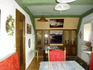 黑林山区贝尔瑙Beautiful apartment in a Black Forest house with conservatory的客厅配有桌子和红色椅子