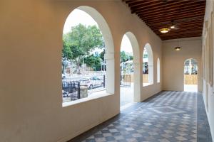 海法Mila - Boutique Hotel的走廊设有拱形窗户,铺有瓷砖地板