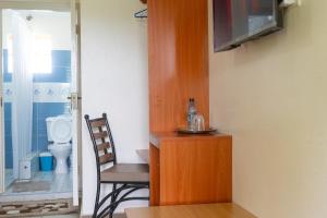 尼耶利Mayas Suites的客房设有桌子、椅子和卫生间。