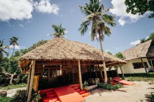 基林多尼Maisara Mafia Beach Lodge的草屋顶和棕榈树的房子