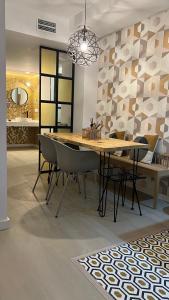 圣安东尼奥Aparthotel Boutique Poniente Playa的一间带木桌和椅子的用餐室