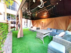 迪拜ELAN RIMAL SADAF Suites的天井配有桌子、沙发和草
