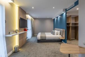 阿雅克修Holiday Inn Express Ajaccio, an IHG Hotel的大型酒店客房设有一张床铺和一张桌子。