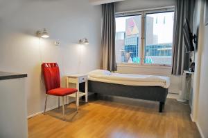 凯拉瓦Hotelli Kerava的卧室配有床、椅子和窗户。