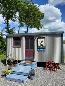 The Hares Hut at Carrigeen Glamping的红门和两个轮子的小棚子