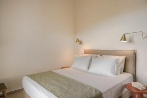 卡拉瓦杜斯罗迪一室公寓的一间卧室配有带白色床单和枕头的床。