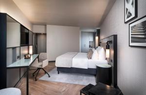 美因河畔法兰克福法兰克福莱昂纳多皇家酒店的配有一张床和一张书桌的酒店客房