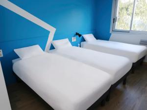 科洛米耶图卢科洛米耶宜必思快捷酒店的蓝色墙壁客房的两张床