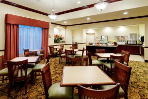 大学城学院站江山套房旅馆的一间带桌椅的餐厅和一间酒吧