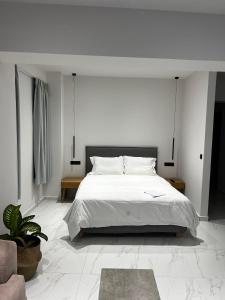 圣加利尼PATRIC.KO的一间白色卧室,配有床和植物