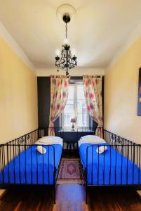 华沙Chmielna Guest House的客厅配有蓝色椅子和吊灯。