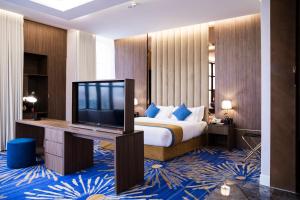 利雅德Novo Hotel的配有一张床和一台平面电视的酒店客房