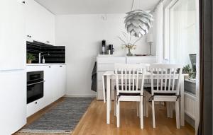 维斯比Nice Apartment In Visby With Wifi的白色的厨房配有白色的桌子和椅子