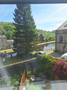 WalsdenTodmorden Bed & Breakfast - The Toothless Mog的享有庭院、树木和房屋的景色