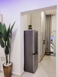 拉各斯Stylish Modern Studio Apartment-Banana Island的厨房配有不锈钢冰箱和盆栽植物