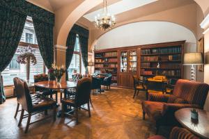 布拉格胡利安酒店的图书馆配有桌椅和书架