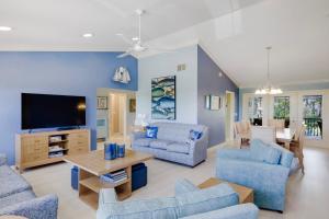 萨尼贝尔Gorgeous 5 Bedroom Home with Heated Pool and Spa的客厅配有蓝色的家具和平面电视。