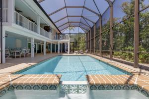 萨尼贝尔Gorgeous 5 Bedroom Home with Heated Pool and Spa的一座玻璃屋顶房子中的游泳池