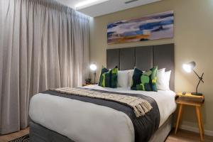约翰内斯堡CAG The Hub Bryanston的一间卧室配有一张带绿色枕头的大床