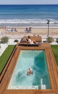 滨海卡瓦莱尔Belle Vue Hôtel的海滩旁的游泳池可容纳2人