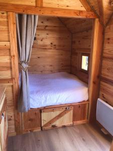GertwillerDomaine Rosfelder - locations de gîte et cabane insolite的小木屋内的卧室,配有一张床