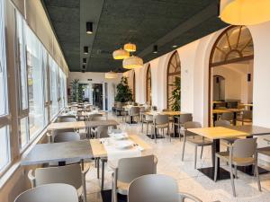 罗萨斯Hotel Marina的餐厅设有桌椅和窗户。