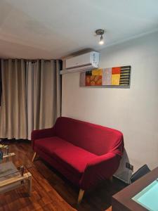圣地亚哥圣伊格纳西奥套房公寓的一间客厅,客厅里设有红色沙发