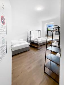 Deutsch-Wagramfeworld living - Deutsch Wagram bei Wien的客房设有两张双层床,铺有木地板。