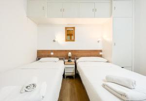 莱塞斯卡尔德-恩戈尔达Apartamento reformado Central park en el centro de Andorra的配有白色墙壁的小客房内的两张床