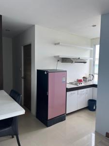 罗勇Banchaitalay Room的一间厨房,里面配有粉红色的冰箱