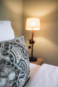 拉马蒂埃勒拉维拉德安德里亚酒店的一间卧室配有一张带枕头和灯的床