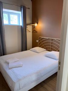 迪关Hôtel Des Docks的一间卧室配有一张带白色床单的床和一扇窗户。