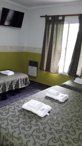 门多萨Hotel Geminis的一间位于地板上带毛巾的带两张床的客房
