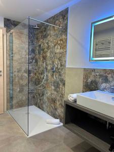 莱德罗Apartments in Pieve di Ledro/Ledrosee 22704的带淋浴、盥洗盆和浴缸的浴室