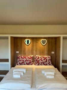 莱德罗Apartments in Pieve di Ledro/Ledrosee 22704的一张带两个枕头的床和墙上的两个心