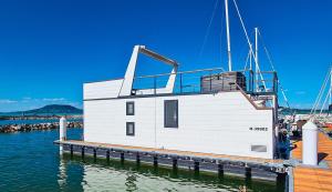 鲍洛通费尼韦什Fenyves Yacht Club Superior的水面上一座白色的小建筑